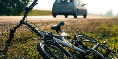 Header image of bicycle accident with the car driving away from the accident.